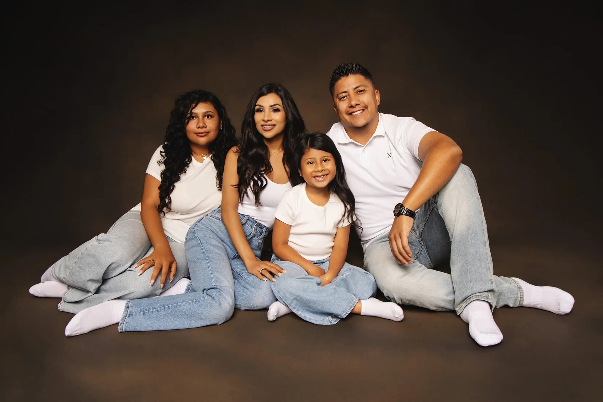 Parents and two children seated together in matching denim in the studio