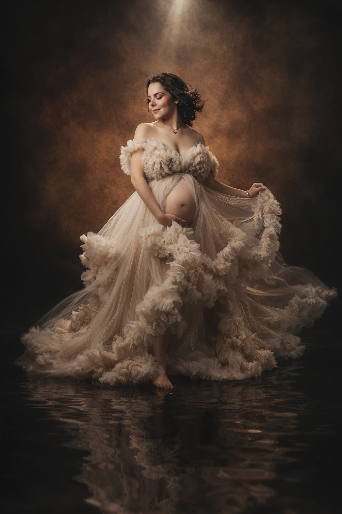 Maternity portrait in a champagne gown with a soft reflection