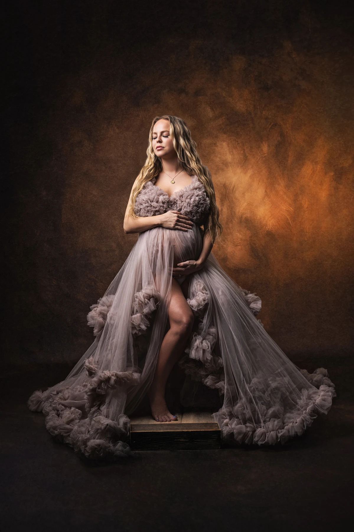 Maternity portrait seated in a full taupe tulle gown