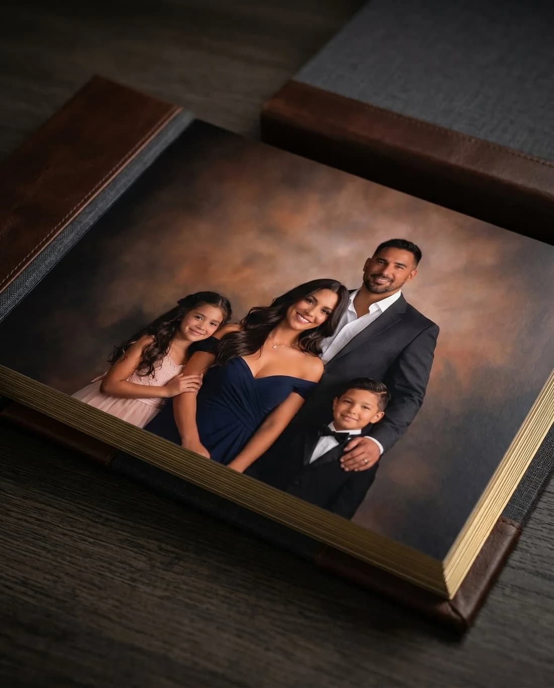 An open fine art portrait album on a wooden table