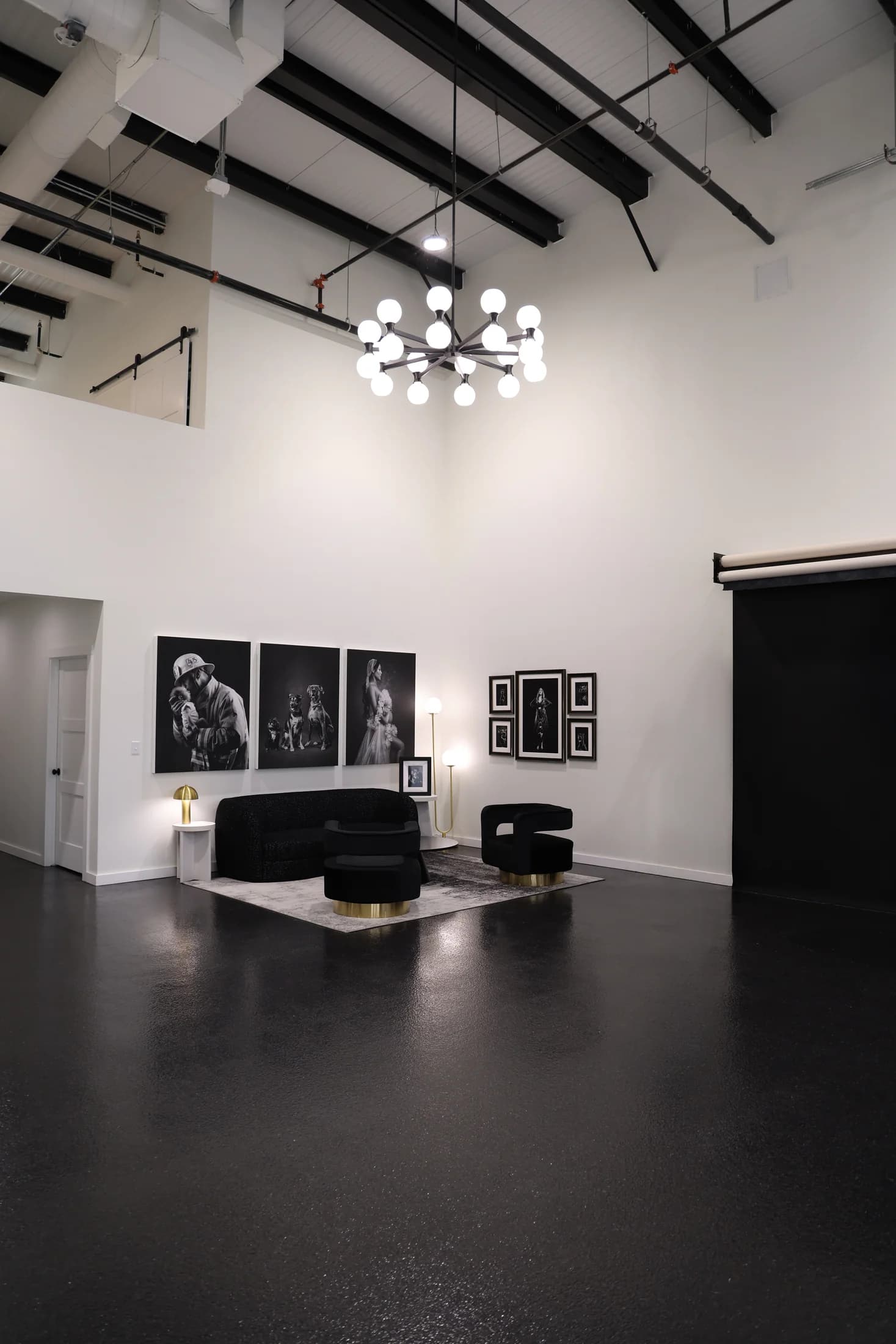 Full view of the McKinney studio with tall ceilings, portrait artwork, seating, and backdrop rolls