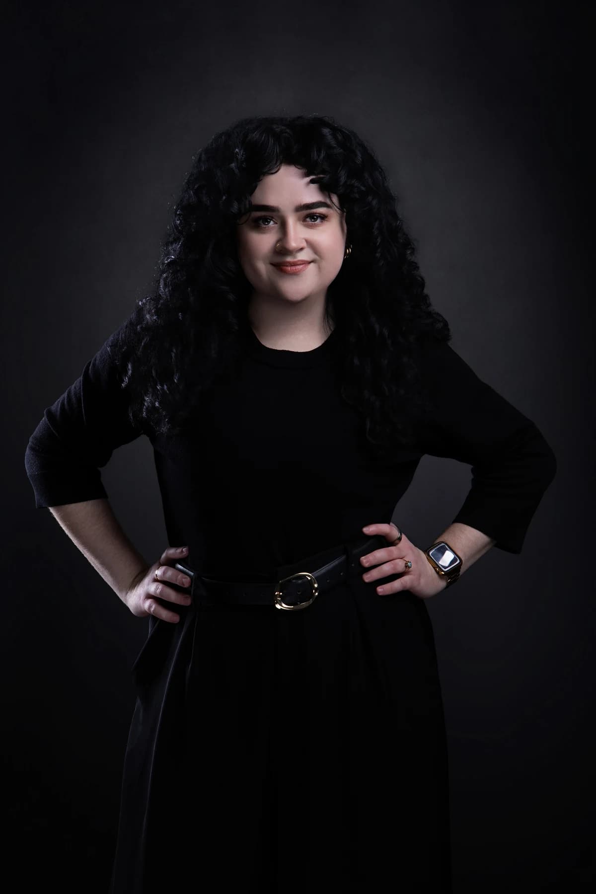 Juniper in a black outfit with her hands on her hips